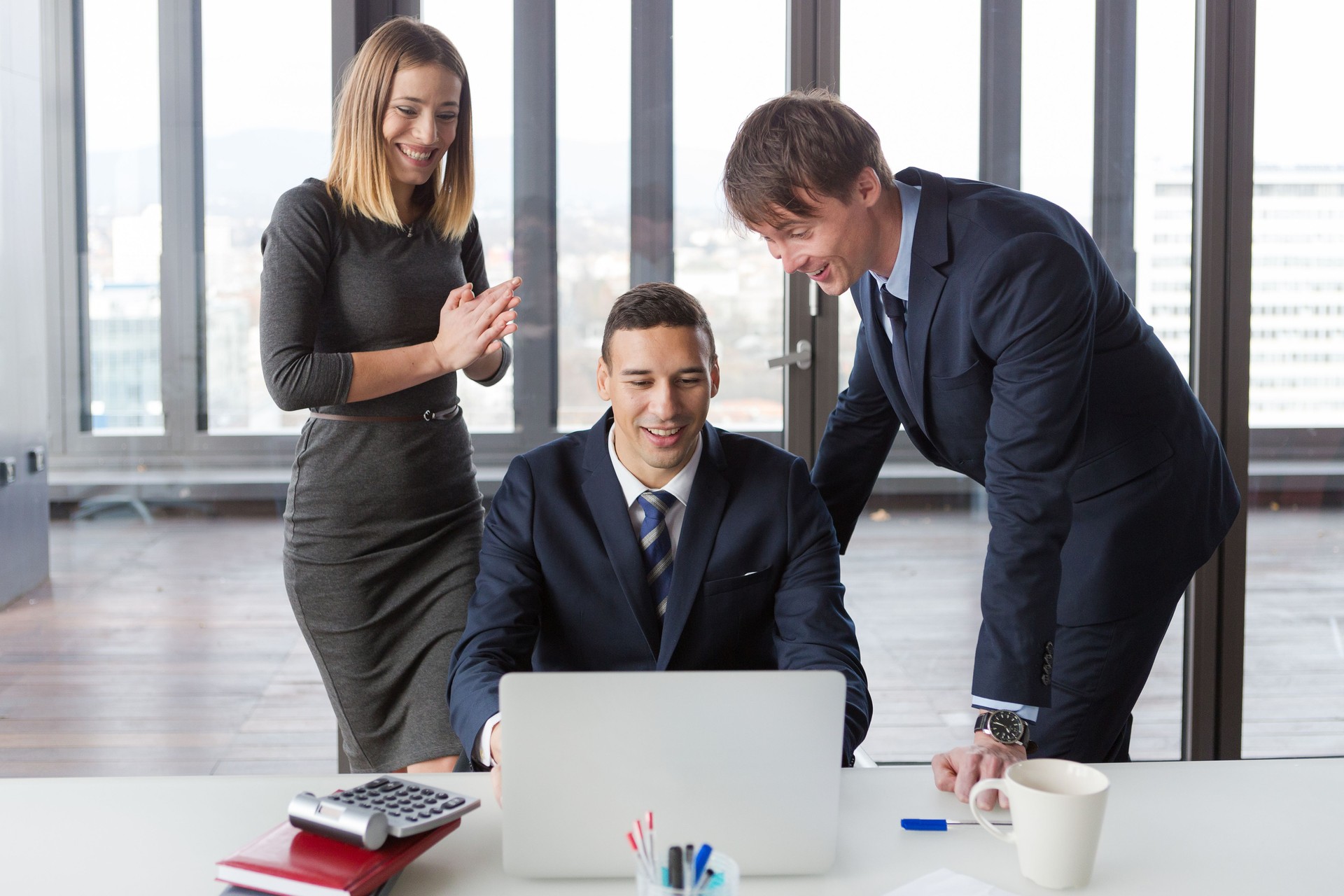 Excited business people in modern office working on project.